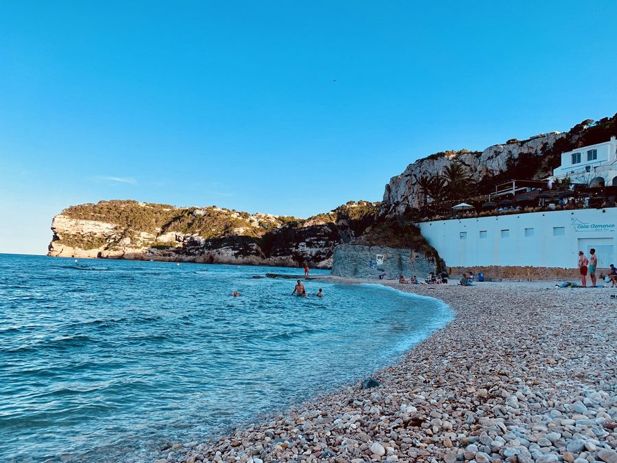 La playa de piedra con Cala Clemence sobre el agua